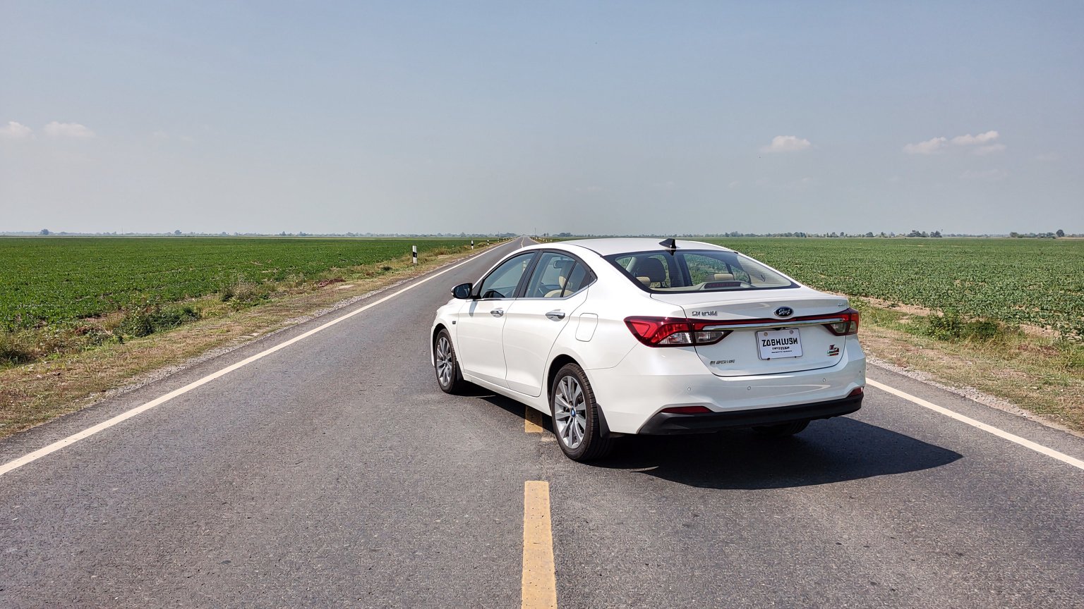 White sedan on a straight road with a clear sky (illustrative image)