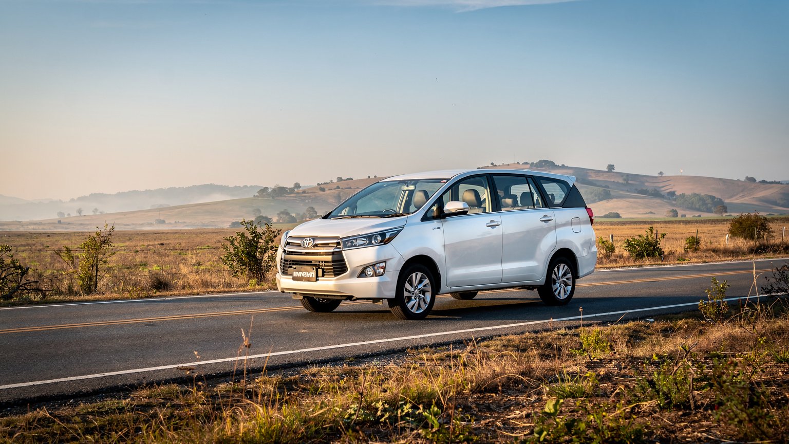 White MPV taxi on a quiet highway in early light (illustrative image)