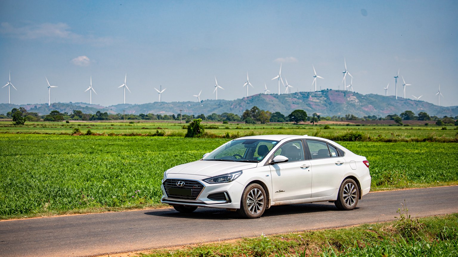 White sedan on a road past wind turbines in western Tamil Nadu (illustrative image)