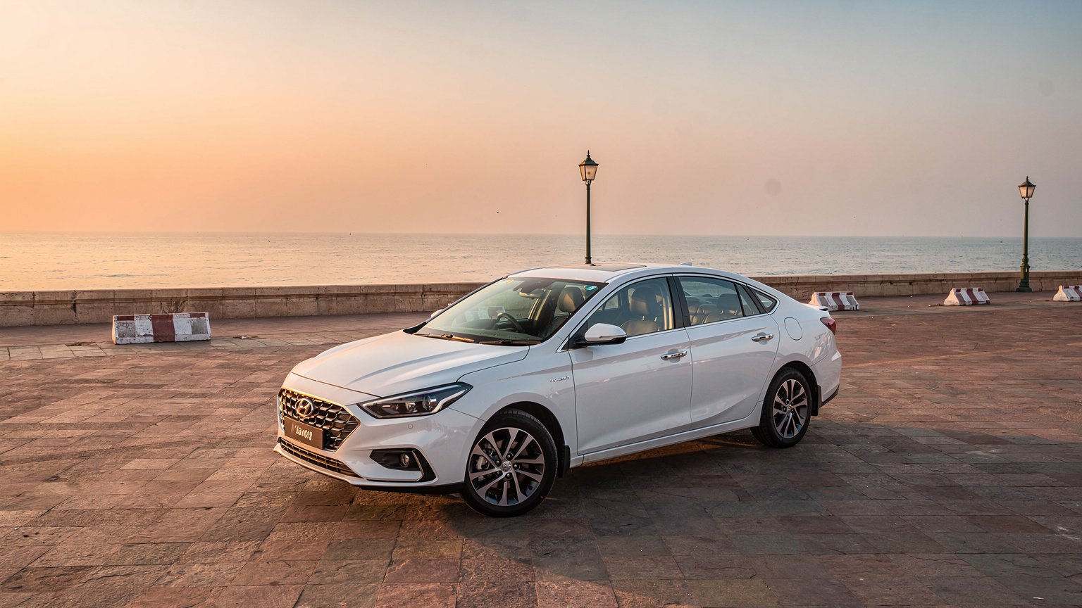 White sedan at a seafront at sunrise in southern India (illustrative image)