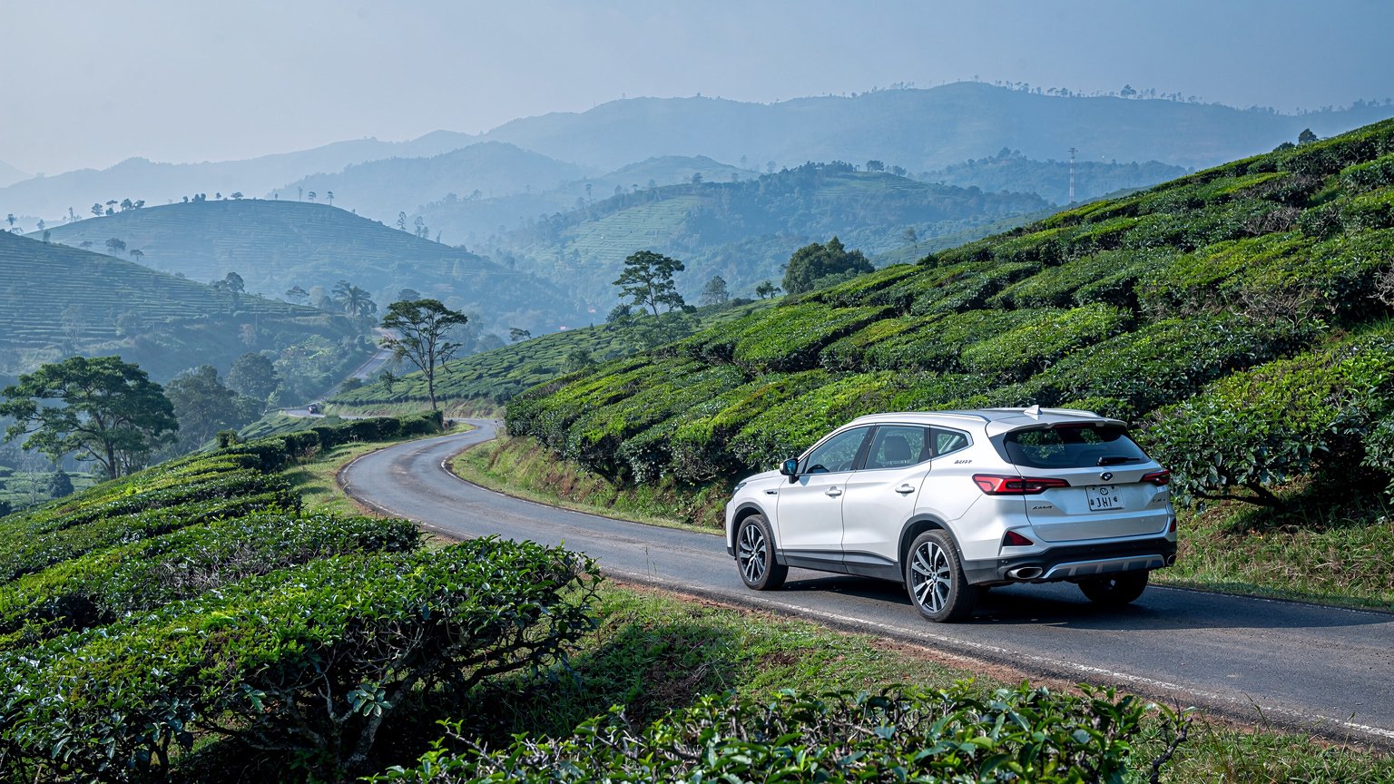 White SUV above tea terraces in the Nilgiri hills (illustrative image)