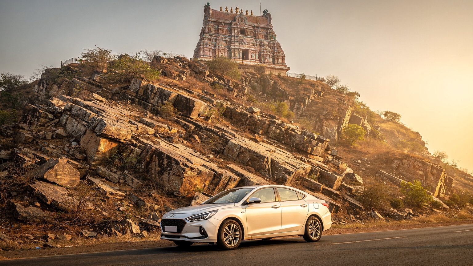 White sedan at the foot of a hill temple in Tamil Nadu (illustrative image)