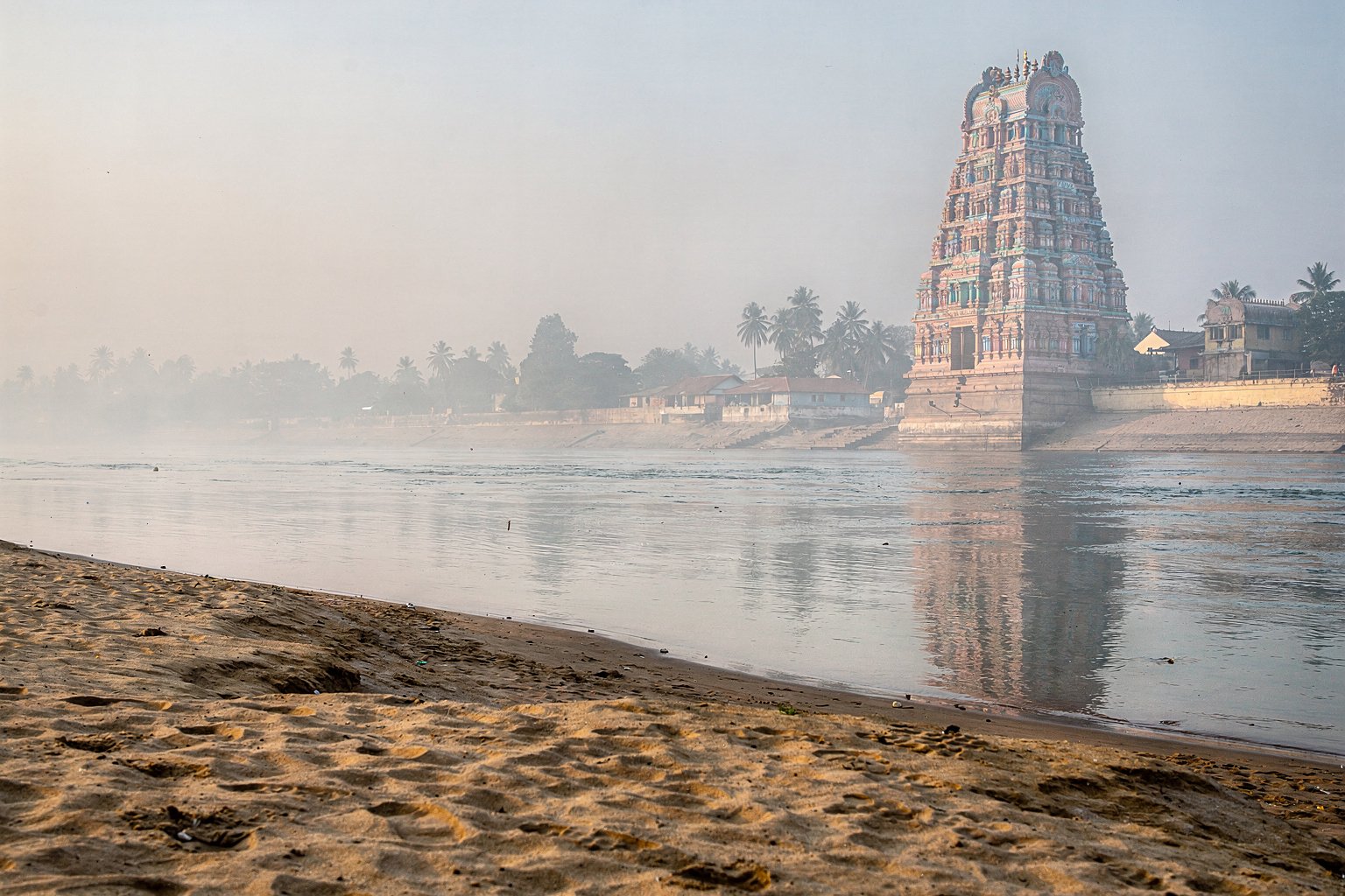 River with a temple tower on the bank in South India (illustrative image)