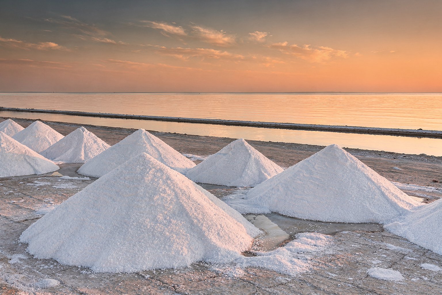 Salt pans beside the sea at sunset (illustrative image)